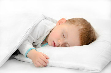 Sleeping baby on white background. Toddler boy in pijama sleeps on white pillow