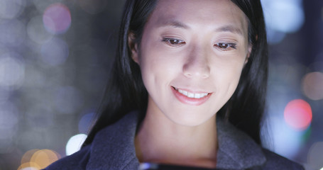 Woman use of tablet computer in city at night