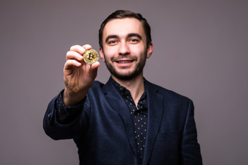 Handome business man pointed bitcoin on camera isolated on dark background