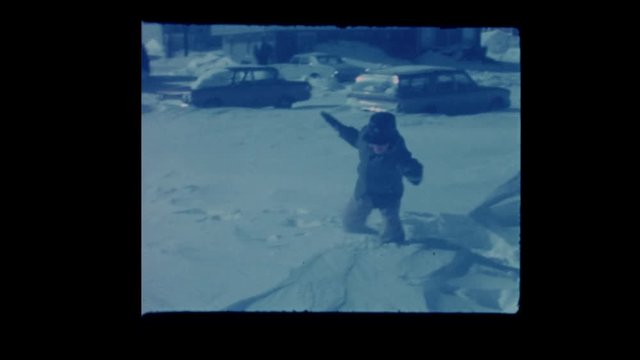 1964 Little boy struggles to walk in deep snow after blizzard