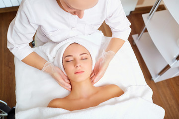 Fototapeta na wymiar Beautiful woman at a facial massage at a spa salon.