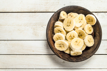 Sliced bananas in a wooden bowl.