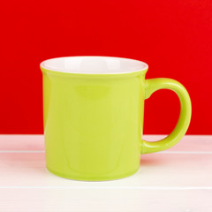 green mug with red background