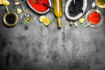 Red and black caviar with wine and lemons.