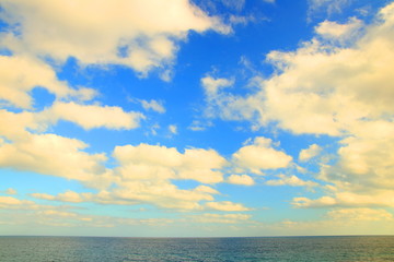 Fototapeta na wymiar Sea horizon and cloudy blue sky