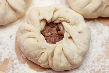 Preparation of belyashes. Traditional russian meat pies belyashi. belyashes on a table. Russian, Bashkir and Tatar cuisine. Top view.