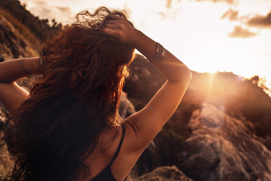 close up of beautiful young woman in rays setting sun