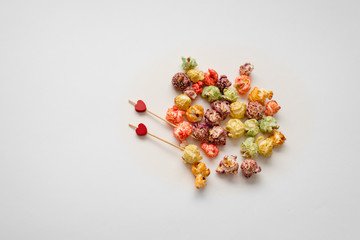Still-life of festive multicolored popcorn on Valentine's day with colorful popcorn and two red hearts on white background