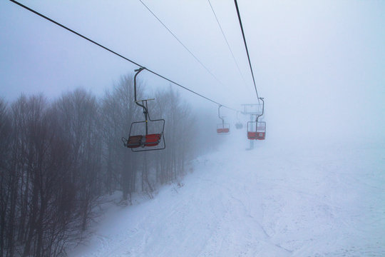 chairlift in misty mountains