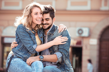 Cheerful smiling couple in love hugging in the street.