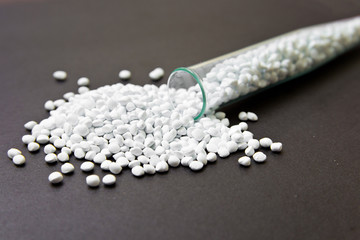 Fototapeta na wymiar Plastic pellets. White Colorant for plastics on a dark background. Plastic Raw material .