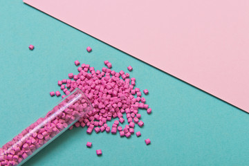 Plastic pellets. Pink Plastic granules on a geometric background. Plastic Raw material .
