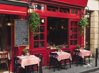 Fototapeta premium Przytulna ulica z stołami kawiarni w Paryżu, Francja