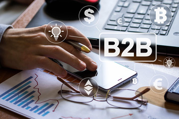 Businessman presses button b2b currency idea on phone virtual electronic user interface.