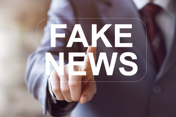 Businessman presses button Fake News media