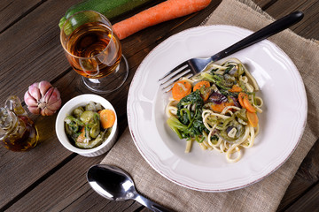 Plate of vegetarian pasta with carrot and zuccini spinach