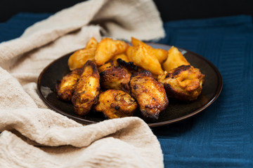 Chicken wings with sauce and golden French fries potatoes