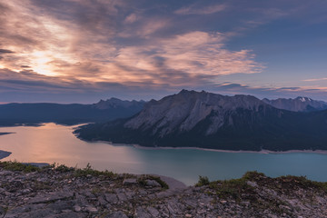 Fototapeta na wymiar Sunrise at Abraham Lake. Camping on a ridge shows the pastel colored sky early in the morning. Calm and warm scene. There are clouds covering most of the sky.