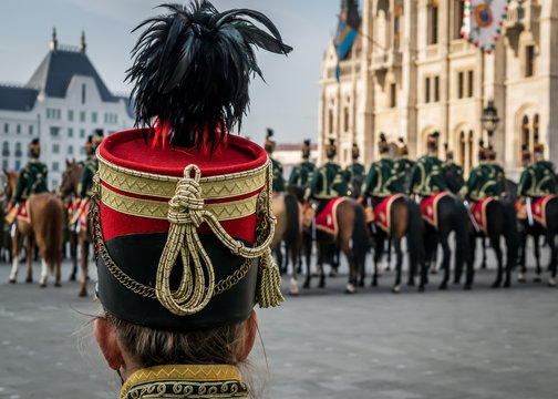Hussar traditional military hat closeup. Background with line up of hussar cavalry on horses in front of the Parliament House during the 15 March military parade in Budapest, Hungary. 