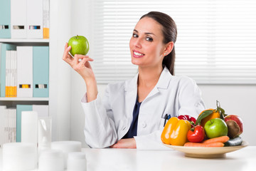  Female nutritionist holding a green apple