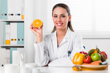 Female nutritionist holding an Orange slice