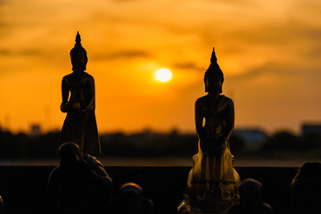 Silhouette buddha statues on blurred sunset background.Thailand.