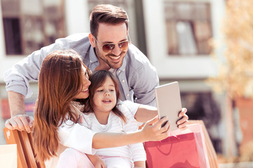 Happy family taking selfie in the city