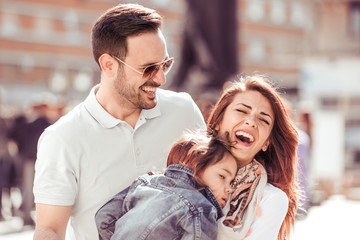 Happy family with little child in the city