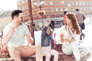 Young happy family of three having fun together outdoor.