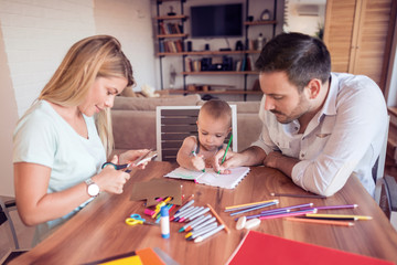 Young parents with young child draw