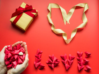 flat lay minimal concept for valentine's day and chinese new year event with lot of heart (origami)in beauty girl hand with love and heart symbol on red background