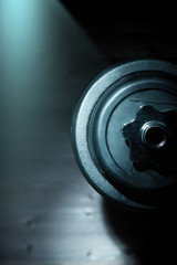 sports dumbbell view in profilesport dumbbell view in profile on a dark background. Space for text
