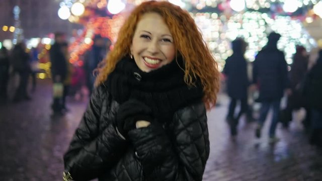 Happy smiling curly red hair walking and have a fun at winter fair city center