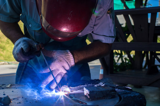 Welder is welding steel plate at the assembly plant.
