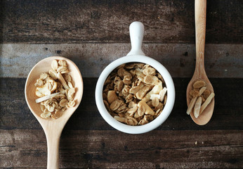 Granola spoon and cup isolated on wood table, top view