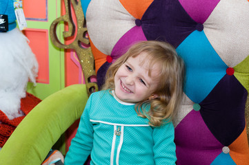 A girl is sitting in an armchair with snowmen in the mall