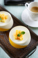 Panna cotta dessert  on a wooden board and coffee mug