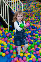 Fototapeta na wymiar Four-year girl playing with balls in the mall