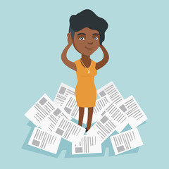 Young african-american desperate business woman clutching head while standing in the heap of papers