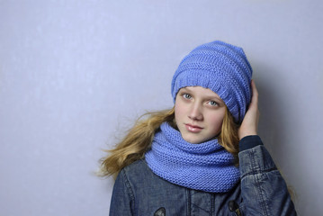 A teenage girl in a knitted cap and scarf.