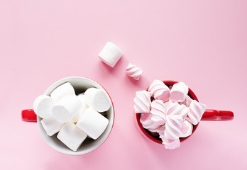 Close-up of marshmallow in cups on pink background.