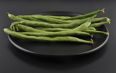 Bohnen auf Teller und schwarzem Hintergrund