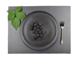 Brombeeren auf Teller und Schiefer