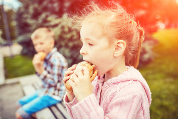 Children on in the park eating a burger
