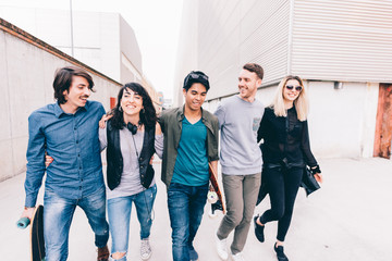 Fototapeta premium Group of friends millennials walking arm aroung outdoor having fun - friendship, interacyion, happiness concept