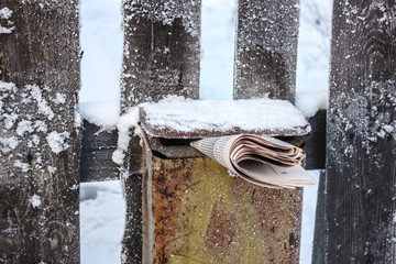 Post box with newspaper in the winter on the street