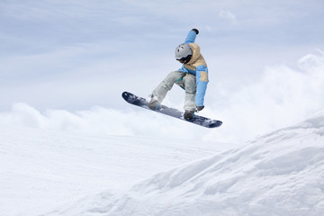Naklejka na ściany i meble Flying snowboarder on mountains. Extreme winter sport.