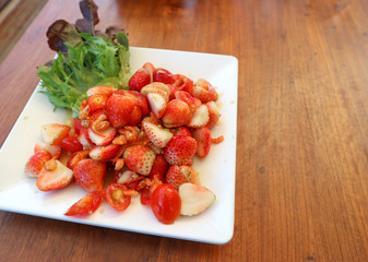 spicy fresh strawberry salad in Thai tasty stlye on copy space wood table.