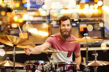 male musician playing cymbals at music store
