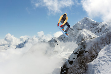 Flying snowboarder on mountains. Extreme winter sport.